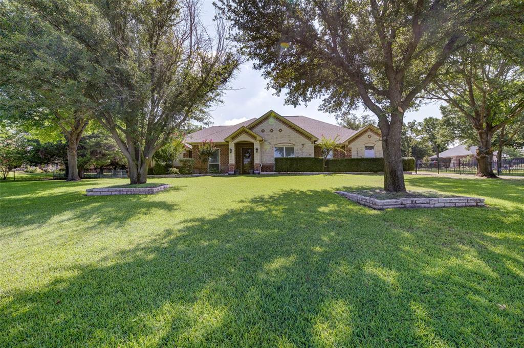 a front view of a house with a yard and trees