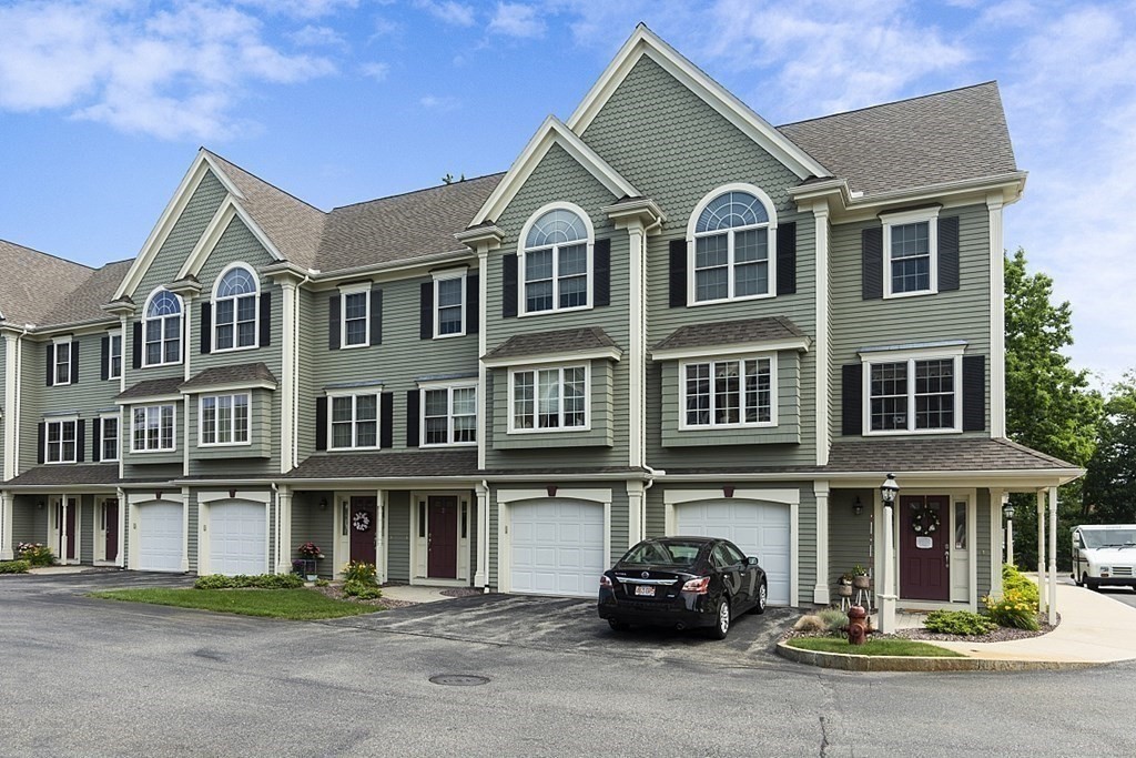 a front view of a house with cars parked