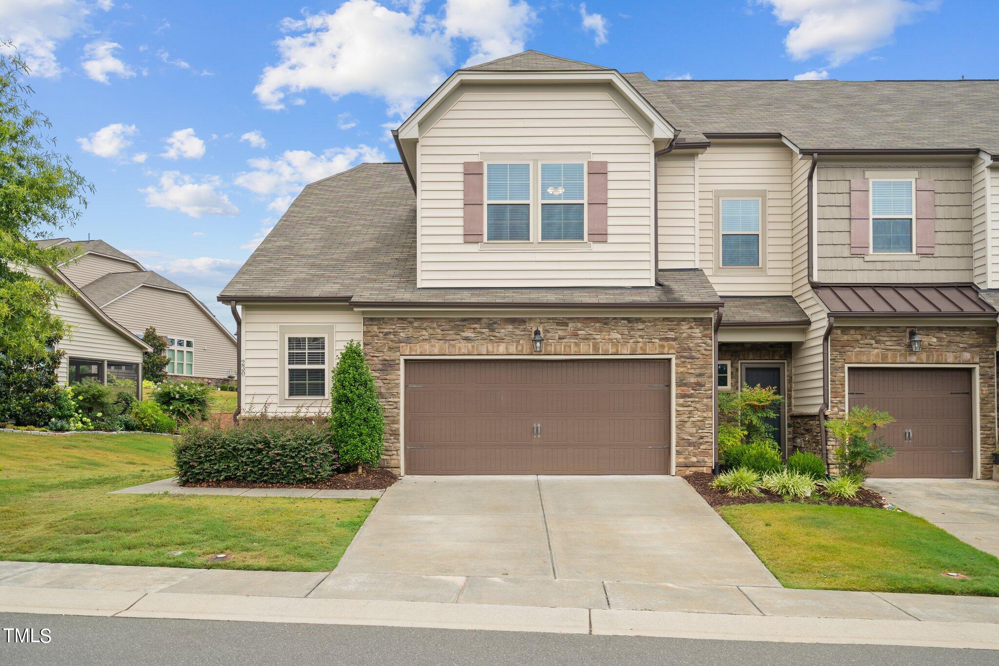 a front view of a house with a yard and garage