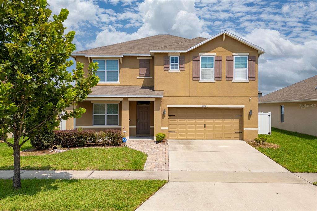 a front view of a house with a yard and garage