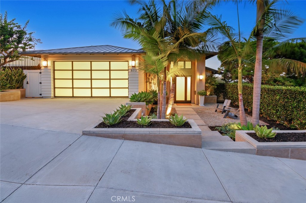 a view of a house with a small yard and a patio