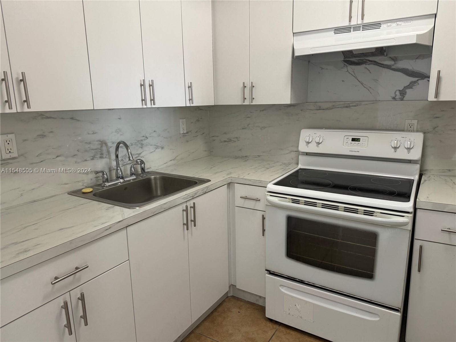 a kitchen with a stove and white cabinets