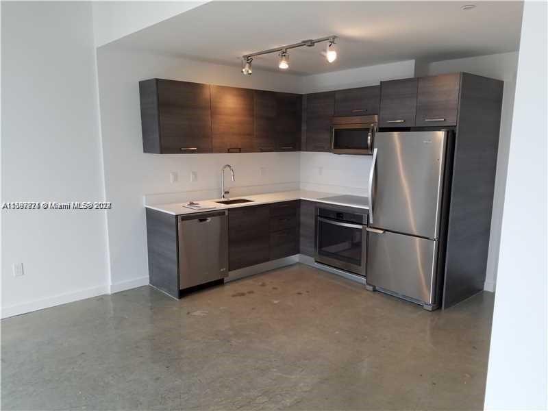 a view of a kitchen with a sink and a refrigerator