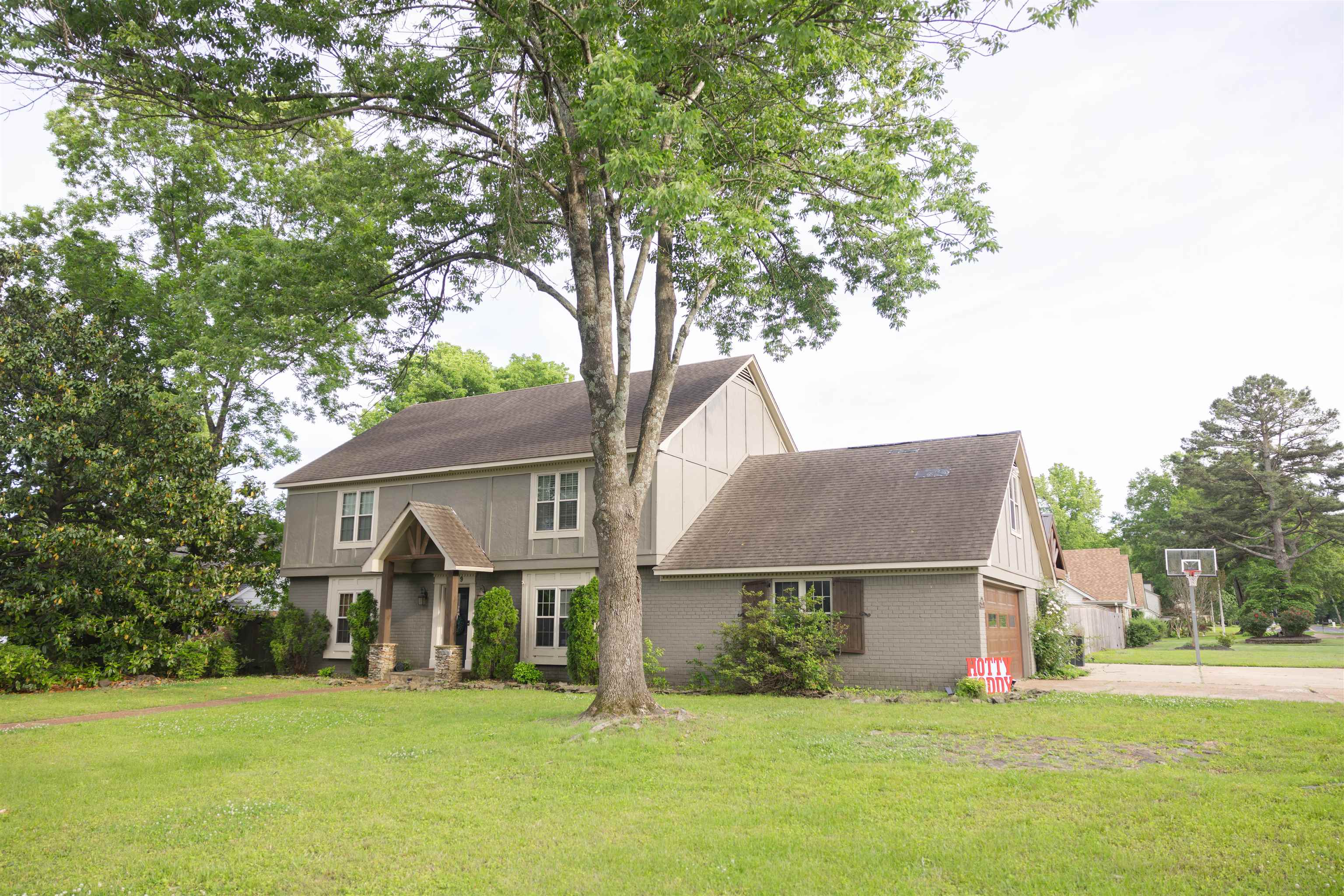 a front view of house with yard and trees around