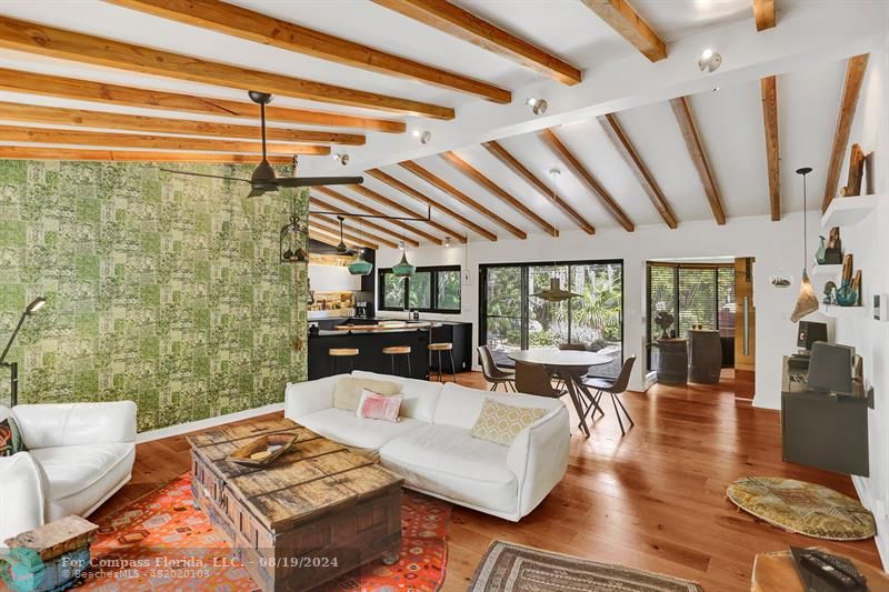 a living room with patio furniture and a floor to ceiling window