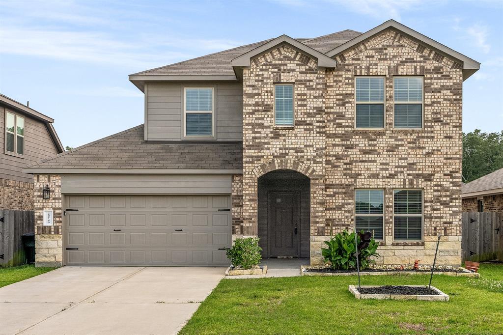 a front view of a house with a yard and garage