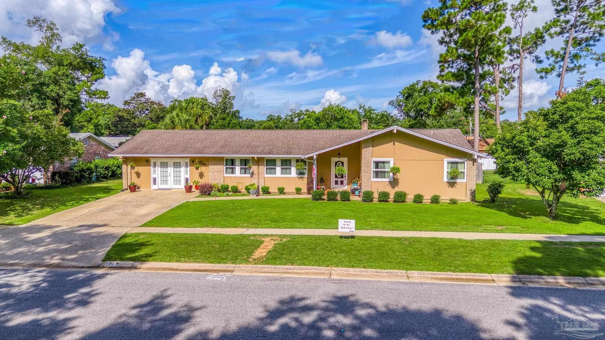 a front view of a house with a yard and trees