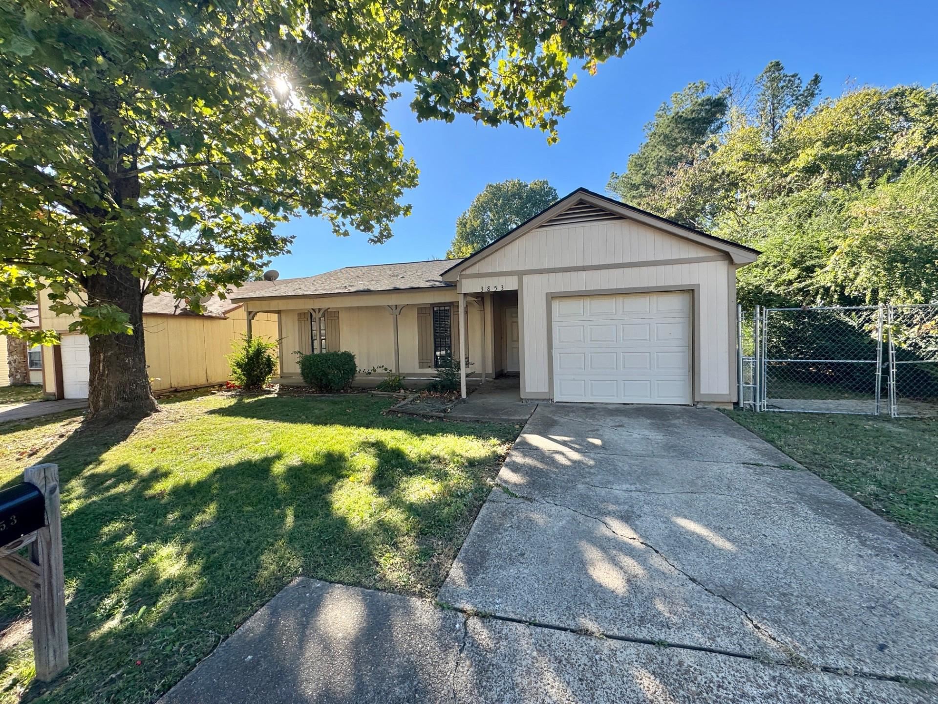 Single story home featuring a garage and a front lawn