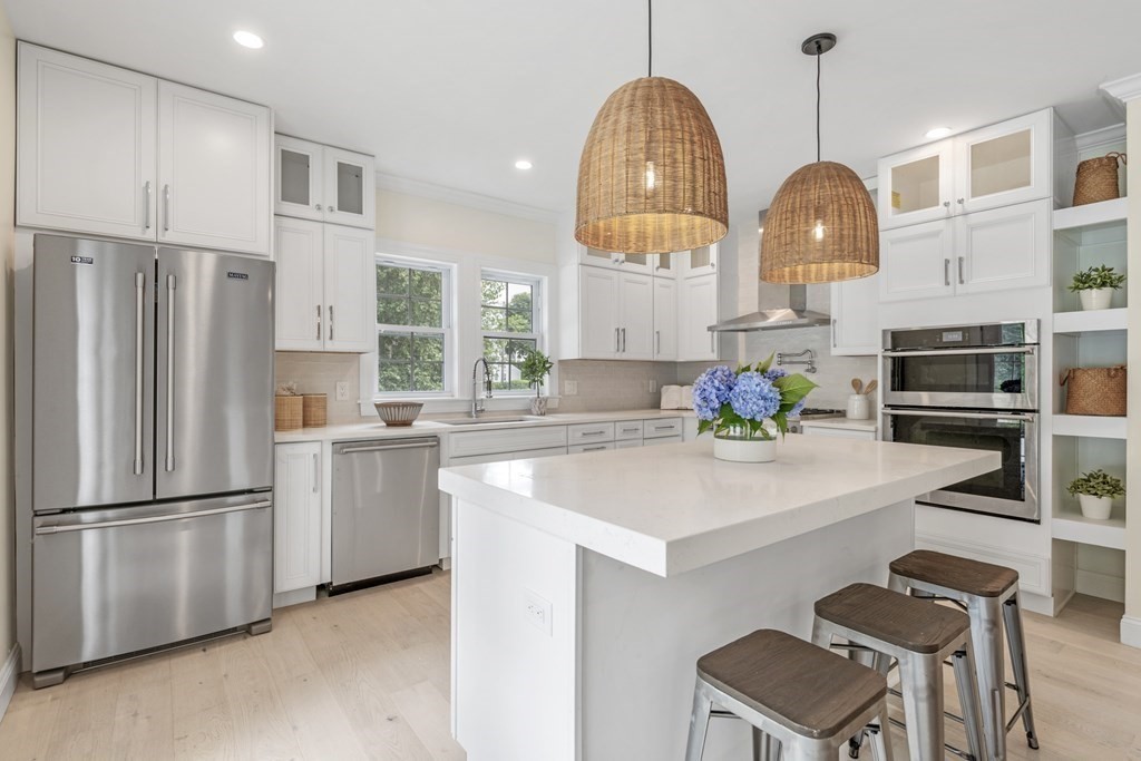 a kitchen with stainless steel appliances a refrigerator a stove a sink and a chandelier