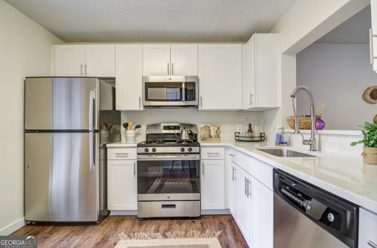 a kitchen with stainless steel appliances a stove a sink and a refrigerator