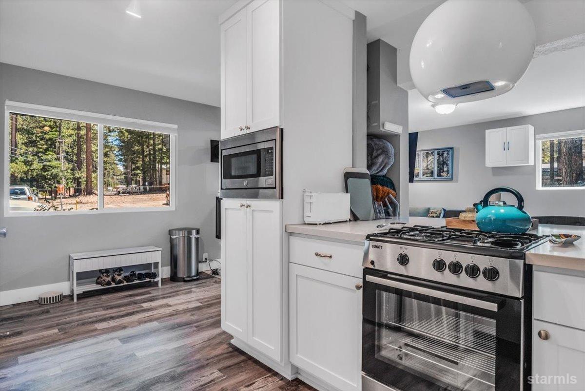 a kitchen with stainless steel appliances a stove a microwave and cabinets