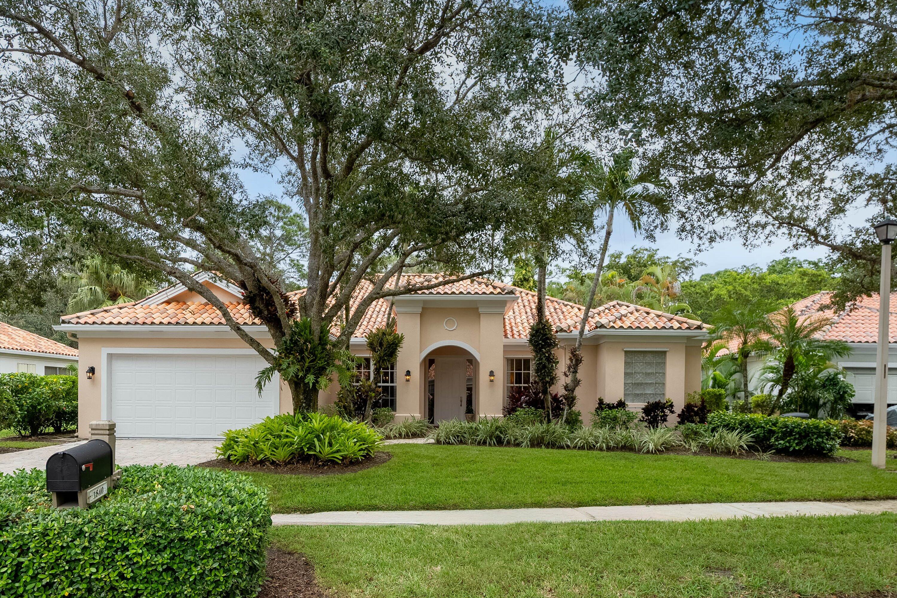 a white house with a big yard and large trees