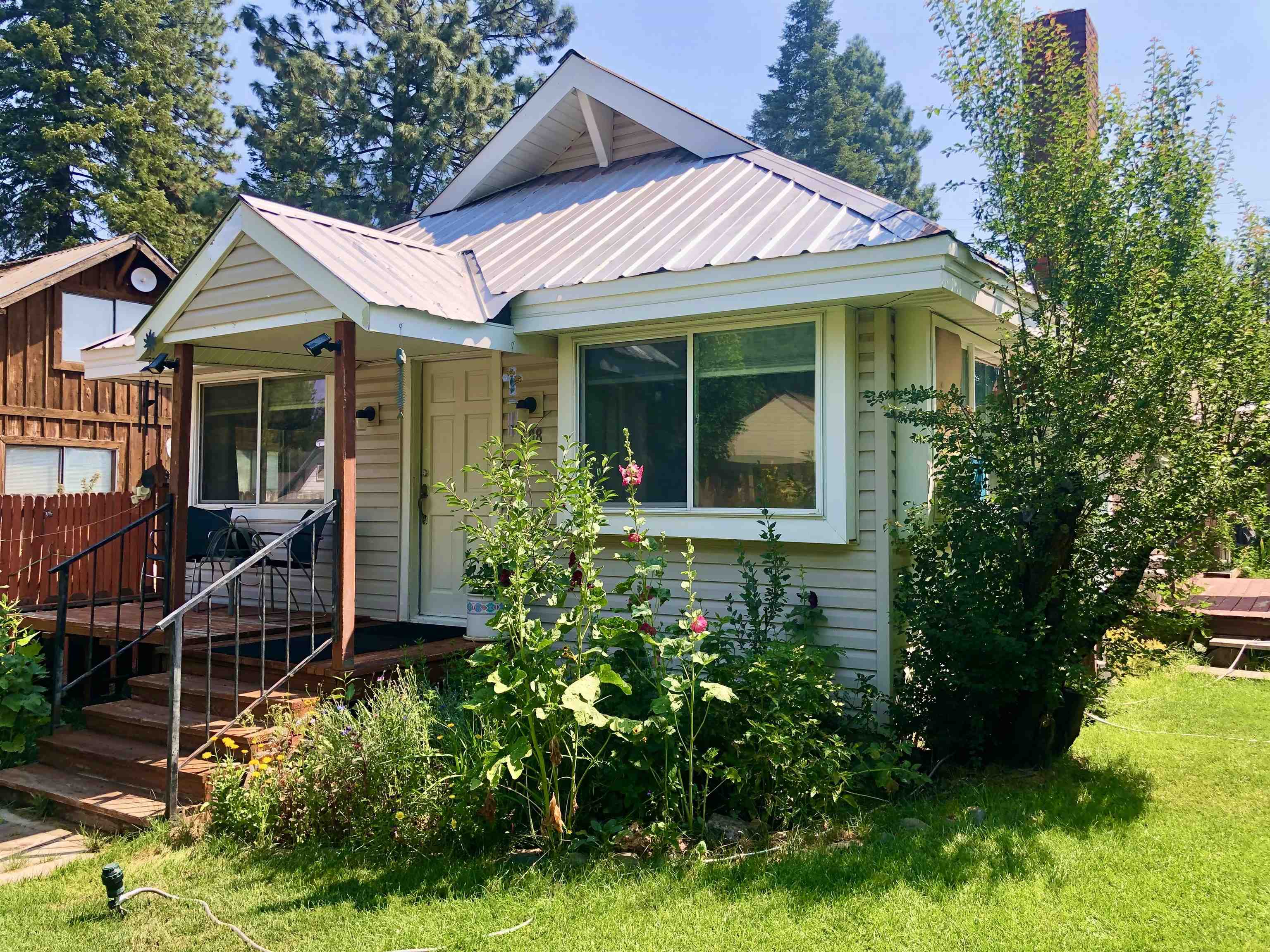 a view of a house with potted plants and a yard