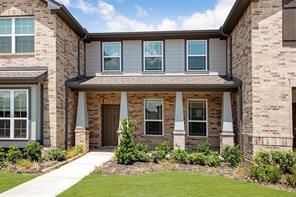 front view of a brick house with a yard