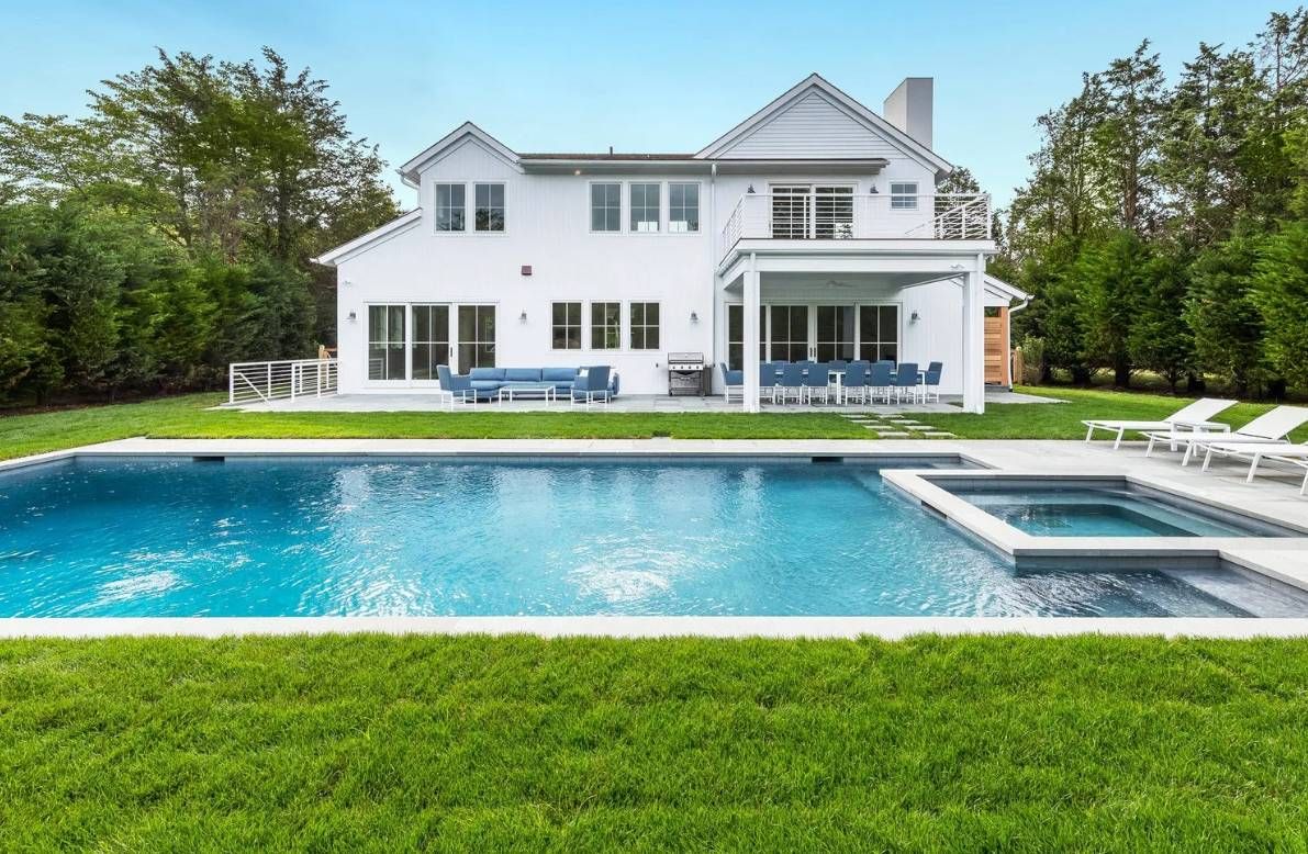 a front view of a house with swimming pool and a yard