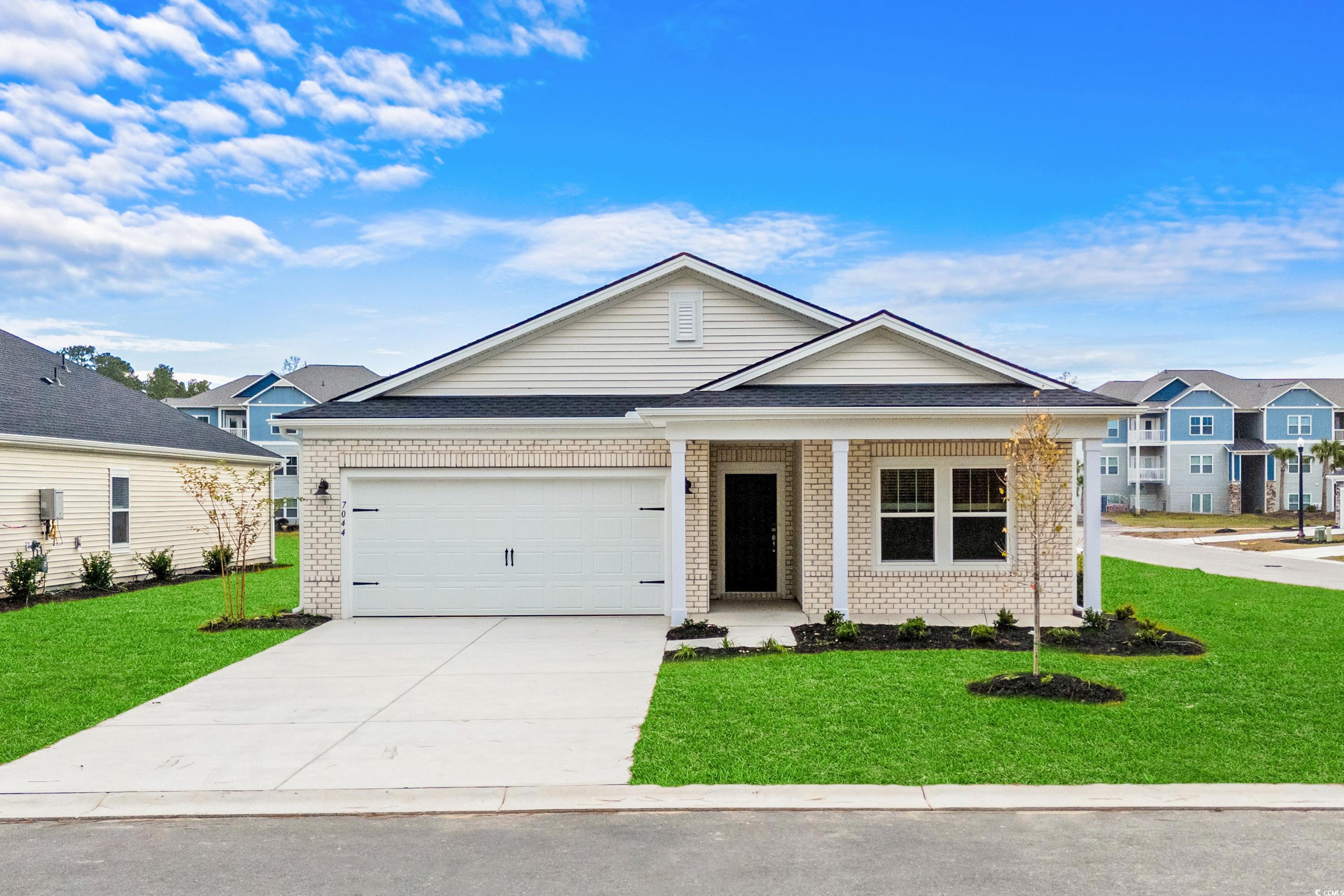 View of front of house with a garage and a front y