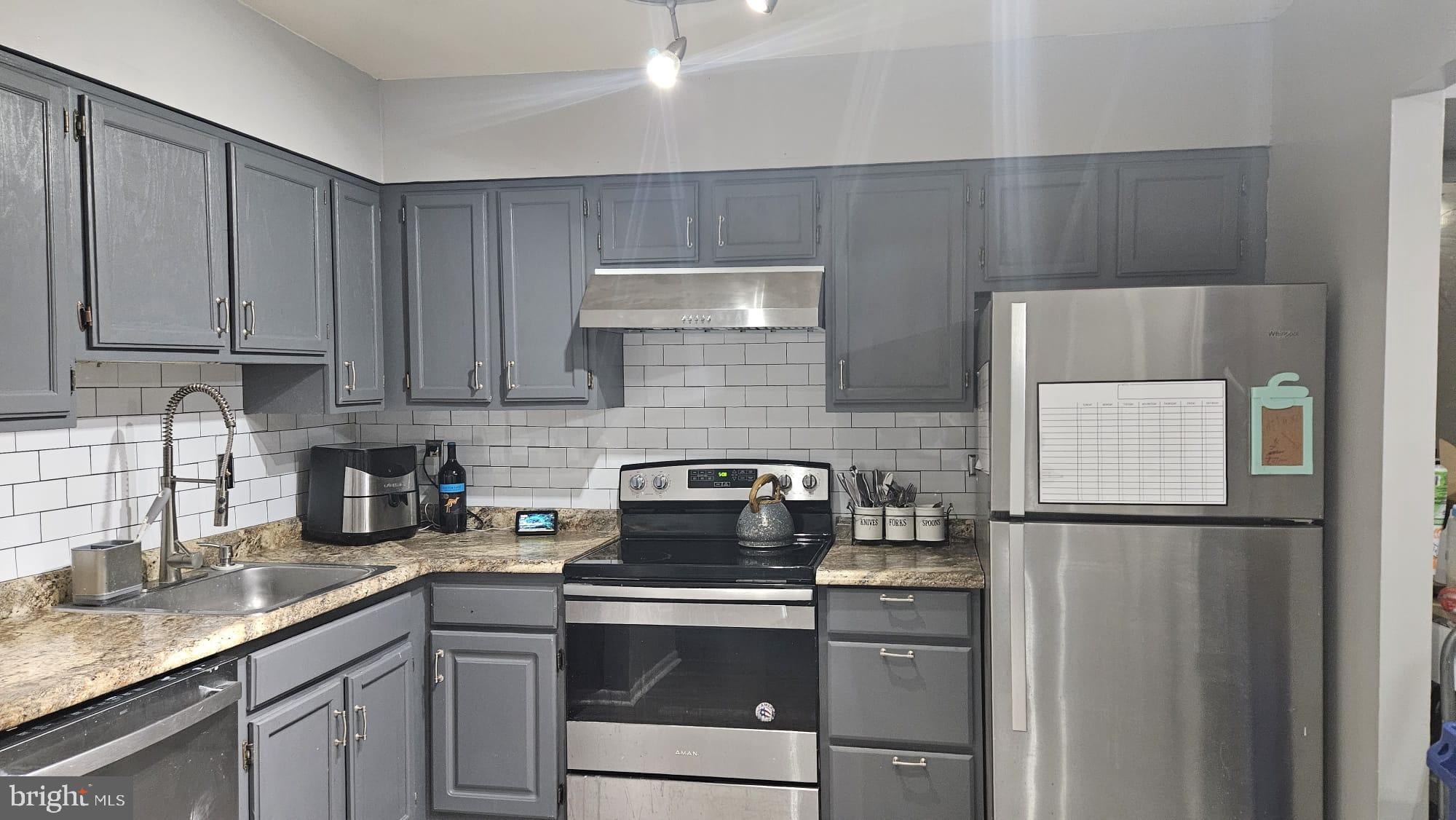 a kitchen with a refrigerator sink and cabinets