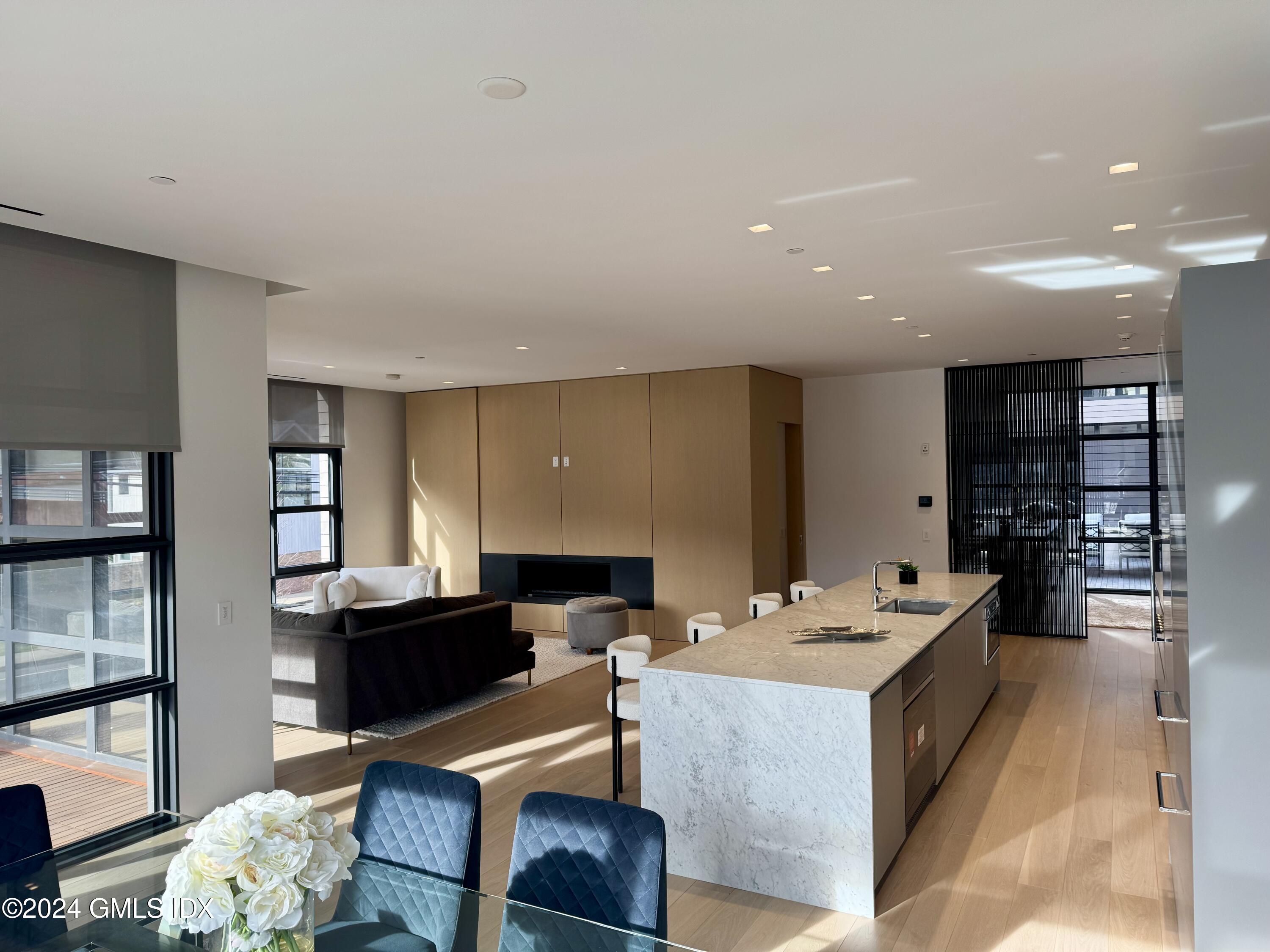 a living room with stainless steel appliances kitchen island granite countertop furniture a rug and a window