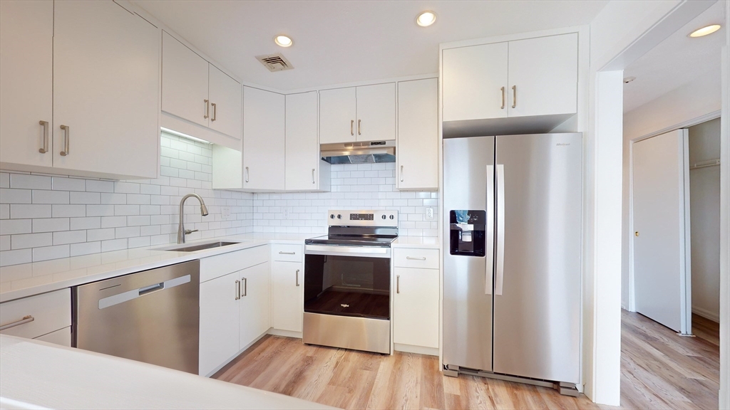 a kitchen with stainless steel appliances a sink stove and refrigerator