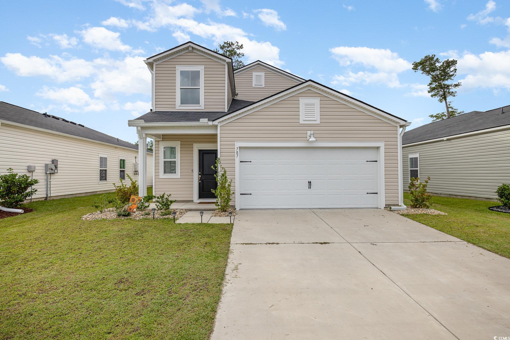 View of front facade with a garage and a front law