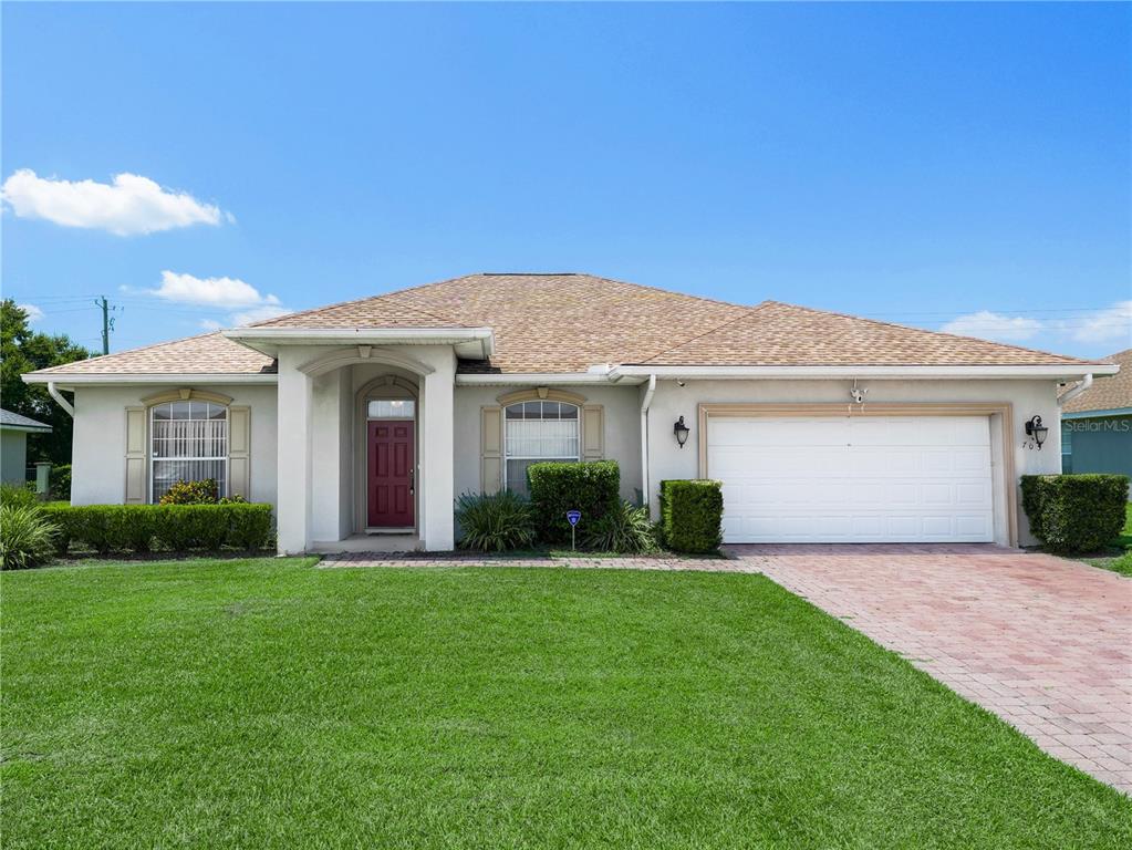 a front view of a house with a yard and garage