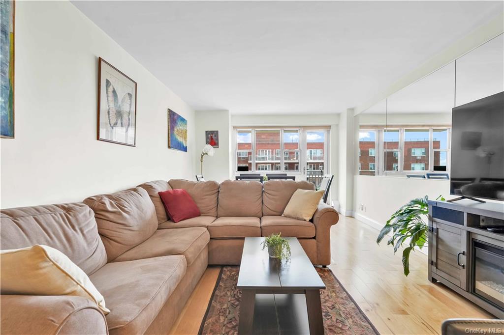 a living room with furniture flat screen tv and a large window