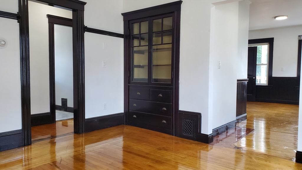 a view of a bedroom with wooden floor and cabinet