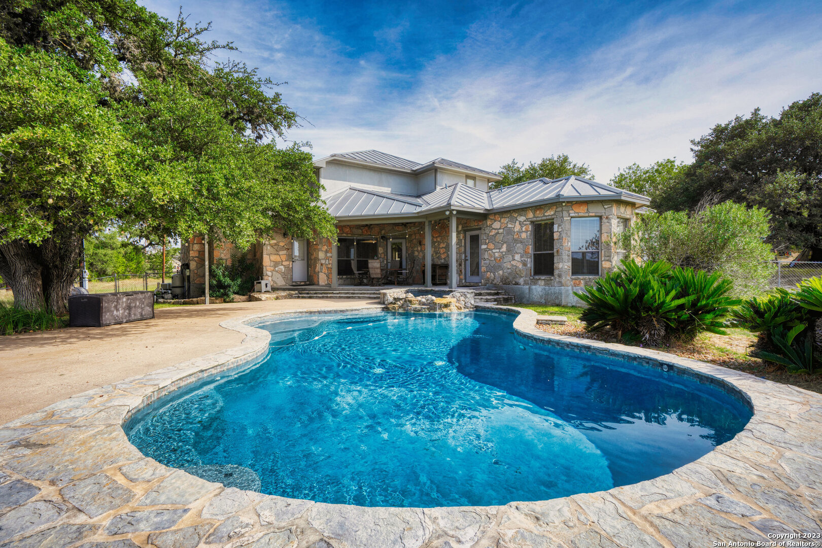 a view of a house with pool plants and palm trees