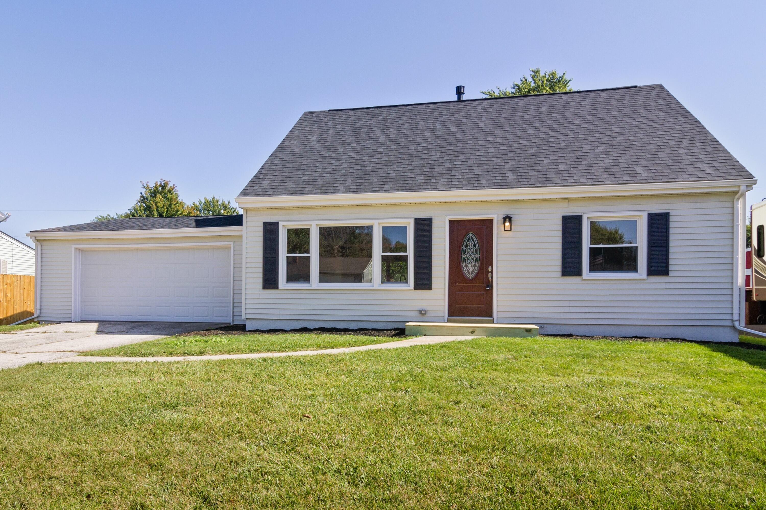 a house that has a big yard and large trees with wooden fence