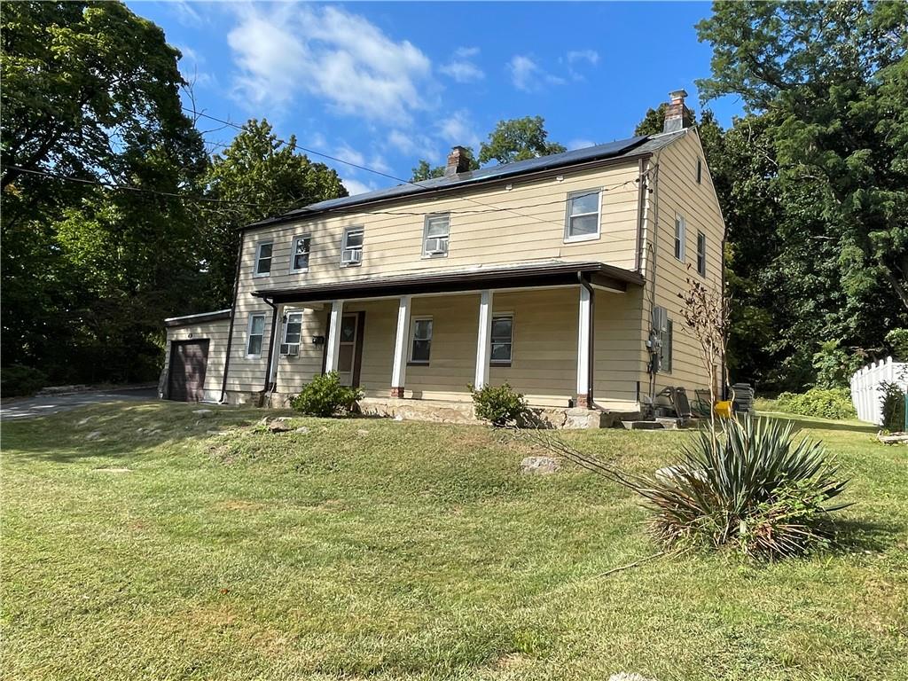 View of front of property with a front lawn and covered porch