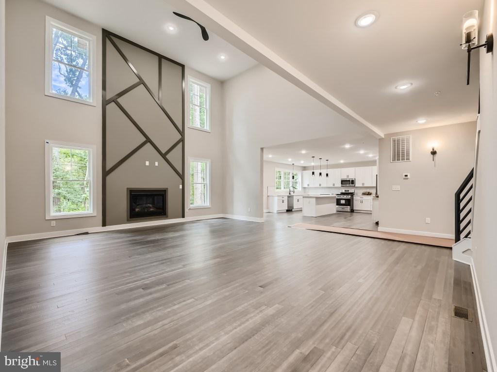 a view of empty room with wooden floor and a fireplace