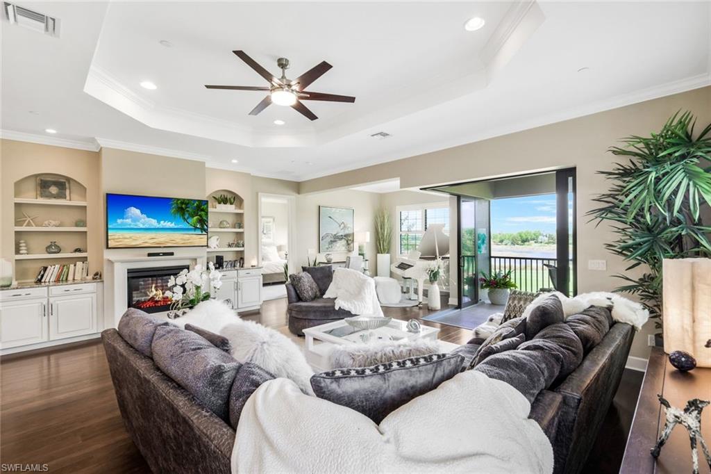 a living room with furniture a fireplace and a large window with wooden floor