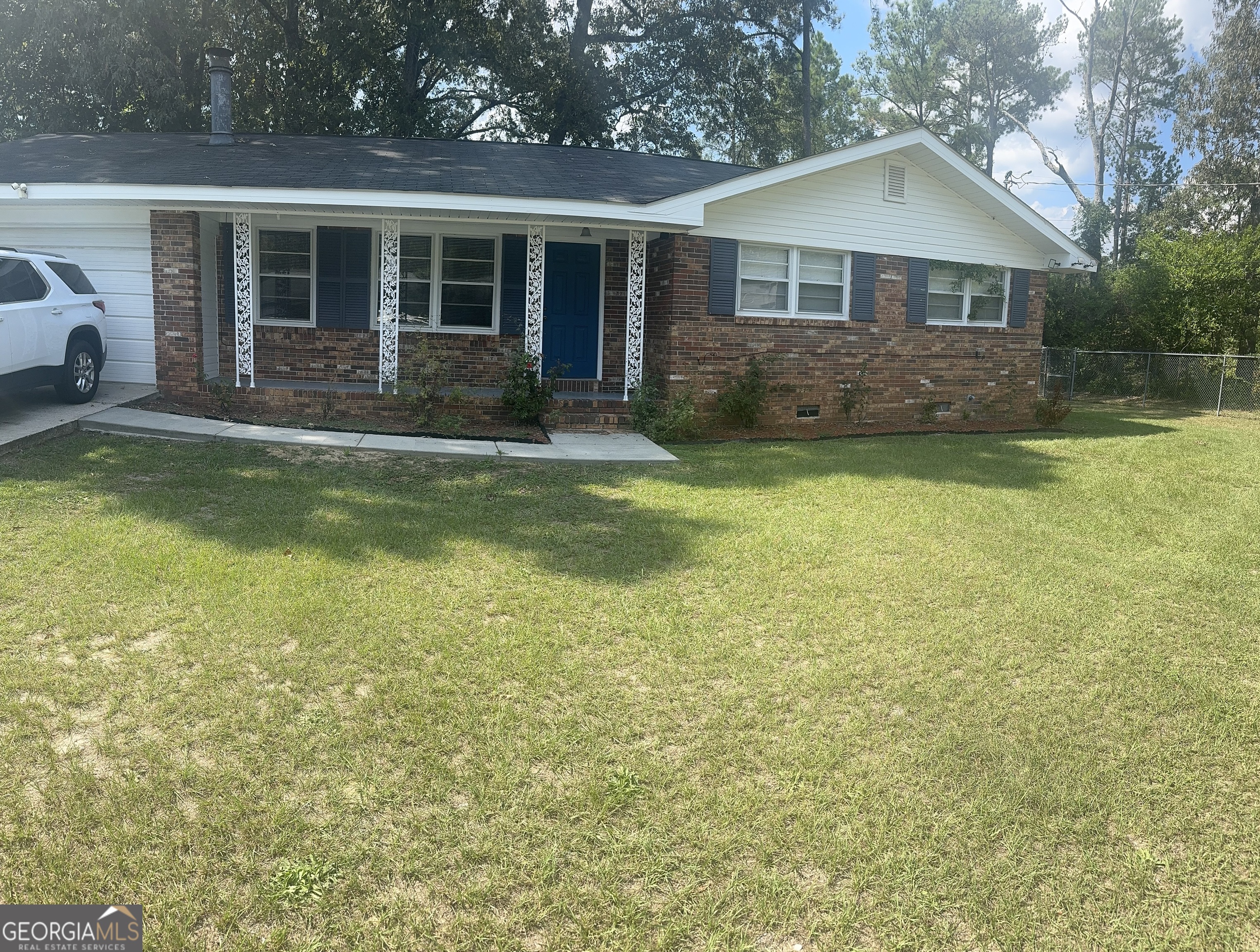 a front view of house with yard and trees around