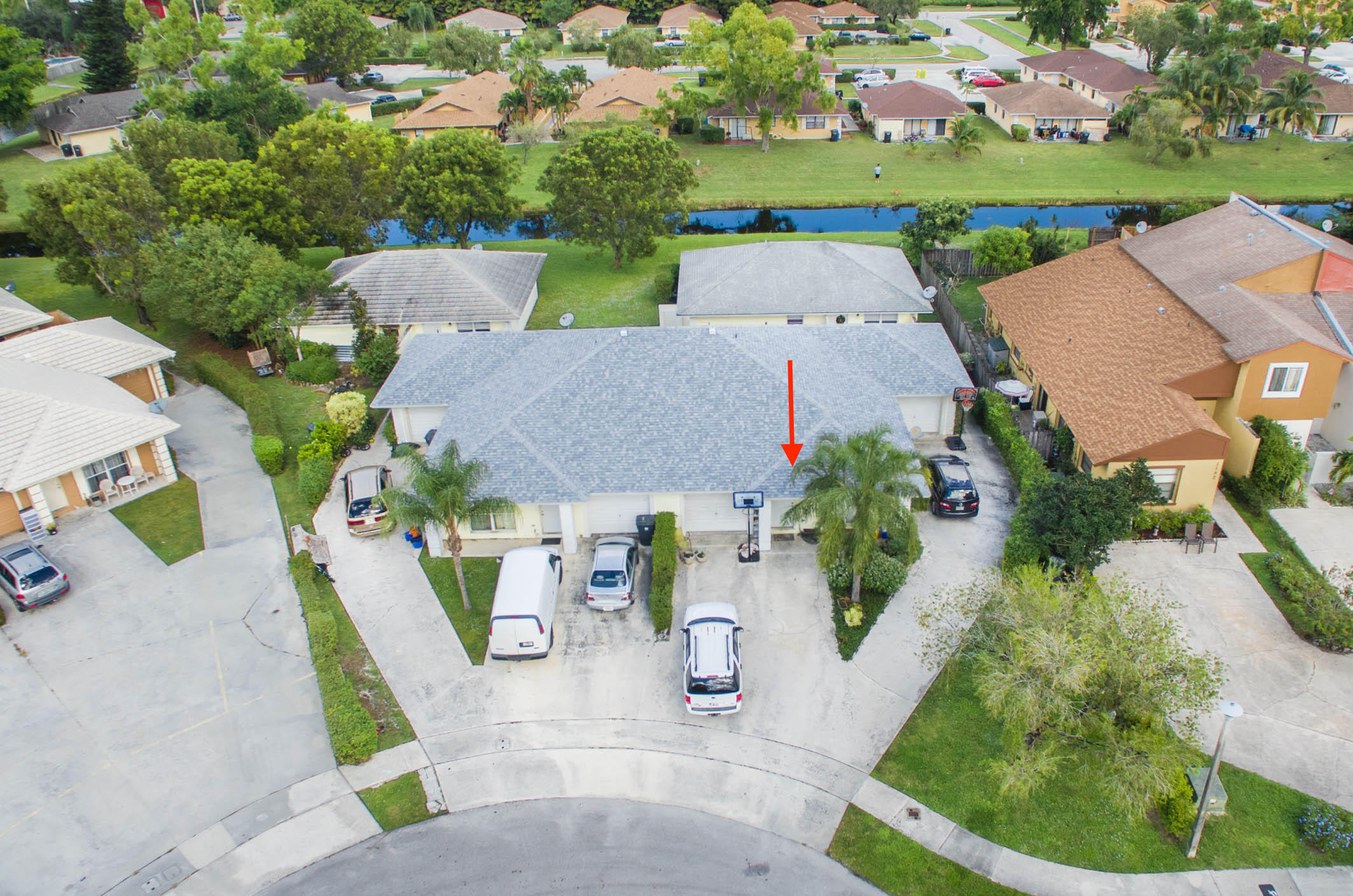 an aerial view of a house with a garden and lake view