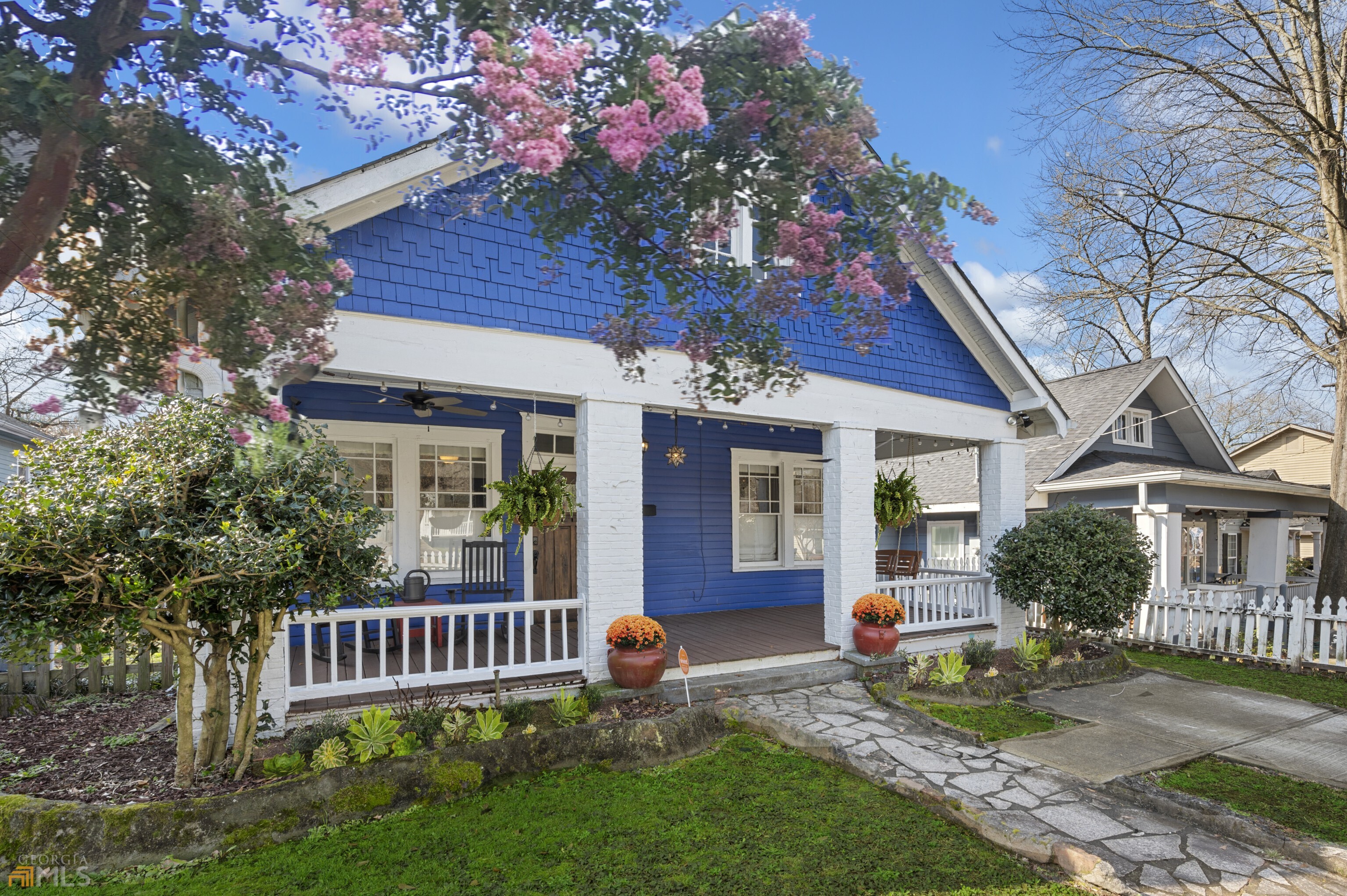 a view of a house with brick walls and a yard with plants