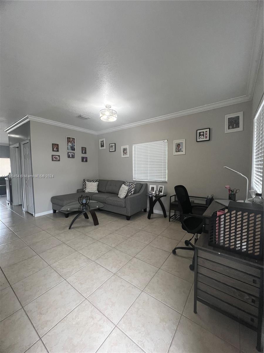 a living room with furniture and a air conditioner vent