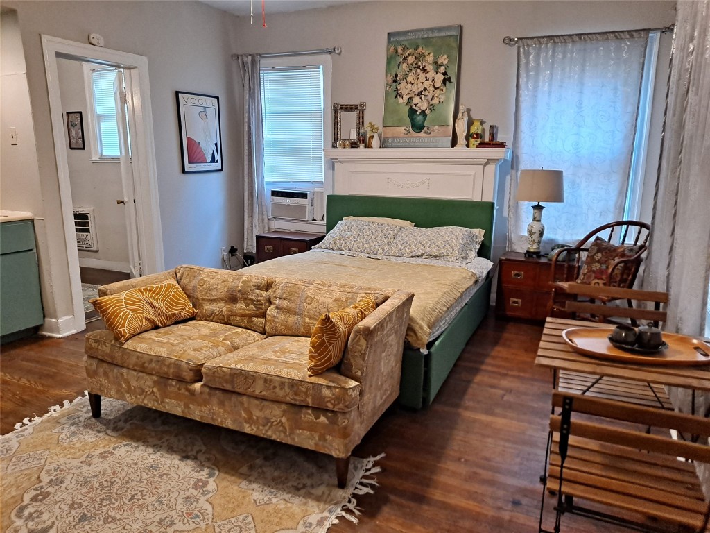 a bedroom with a bed wooden floor and dresser