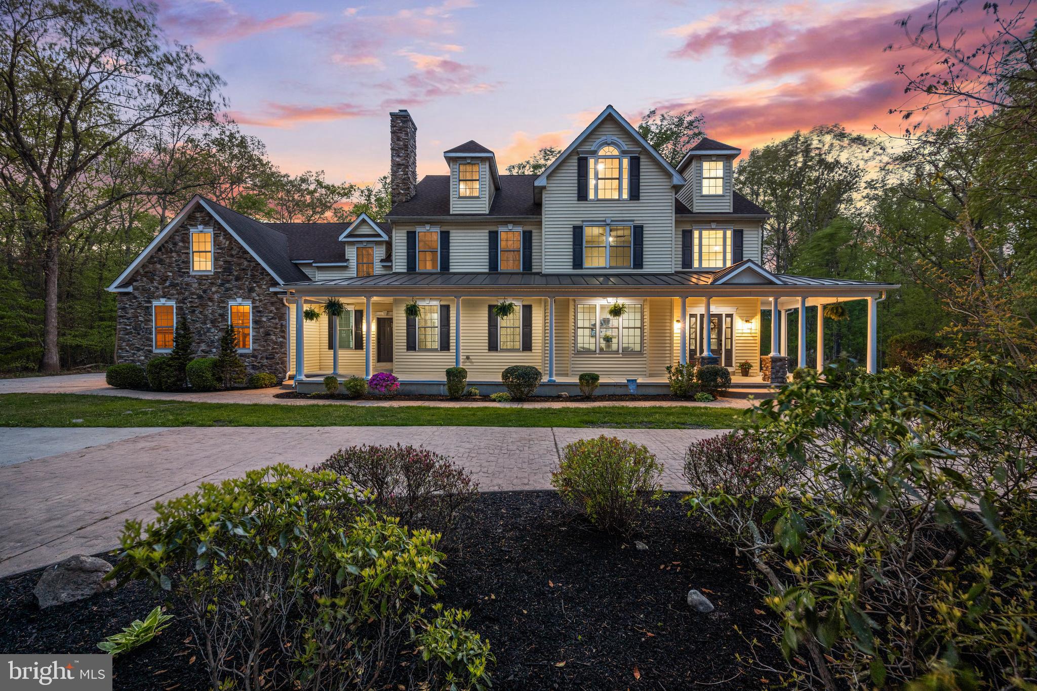 a front view of a house with a garden and lake view