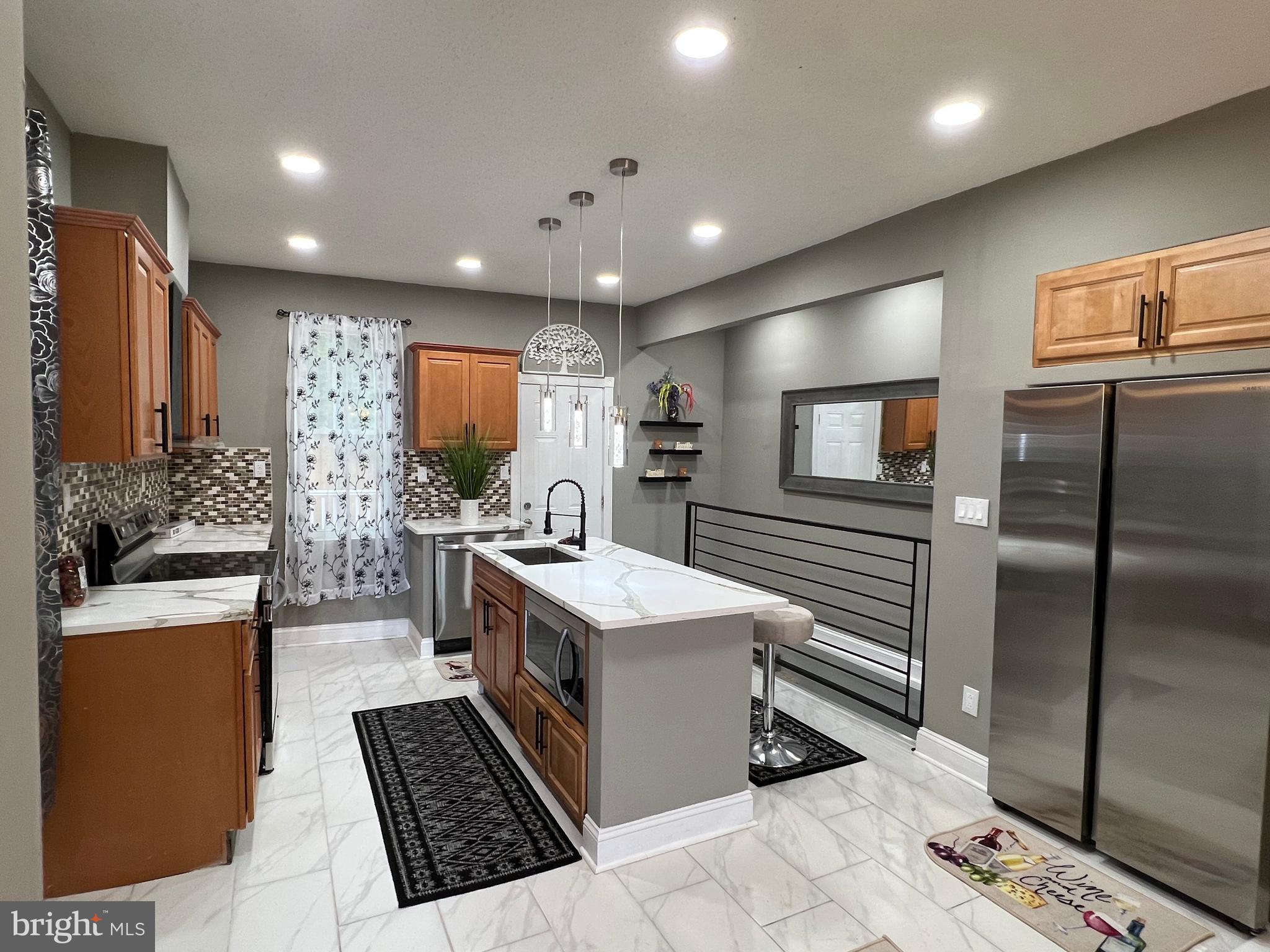 a kitchen with stainless steel appliances granite countertop a sink a stove and a refrigerator