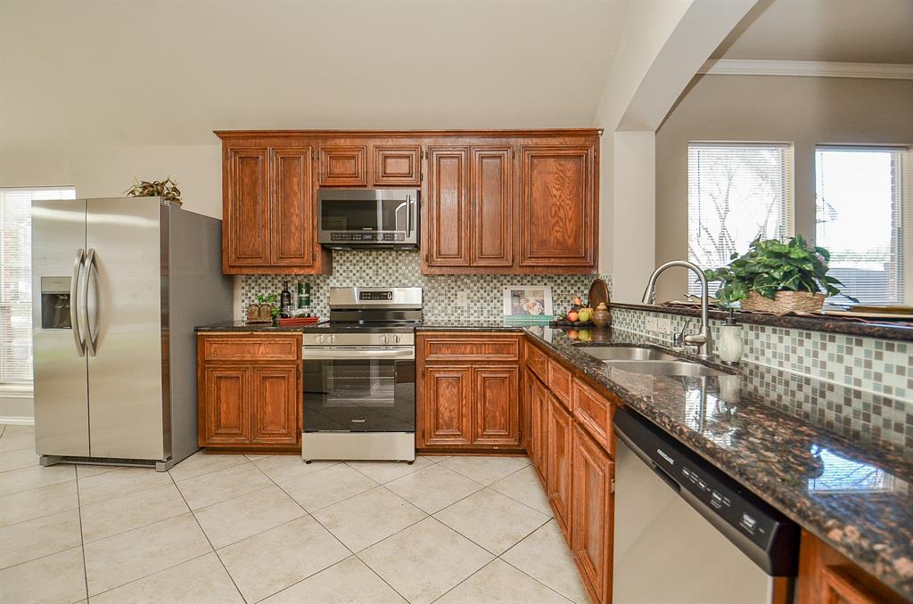 a kitchen with stainless steel appliances granite countertop a stove top oven a sink and dishwasher