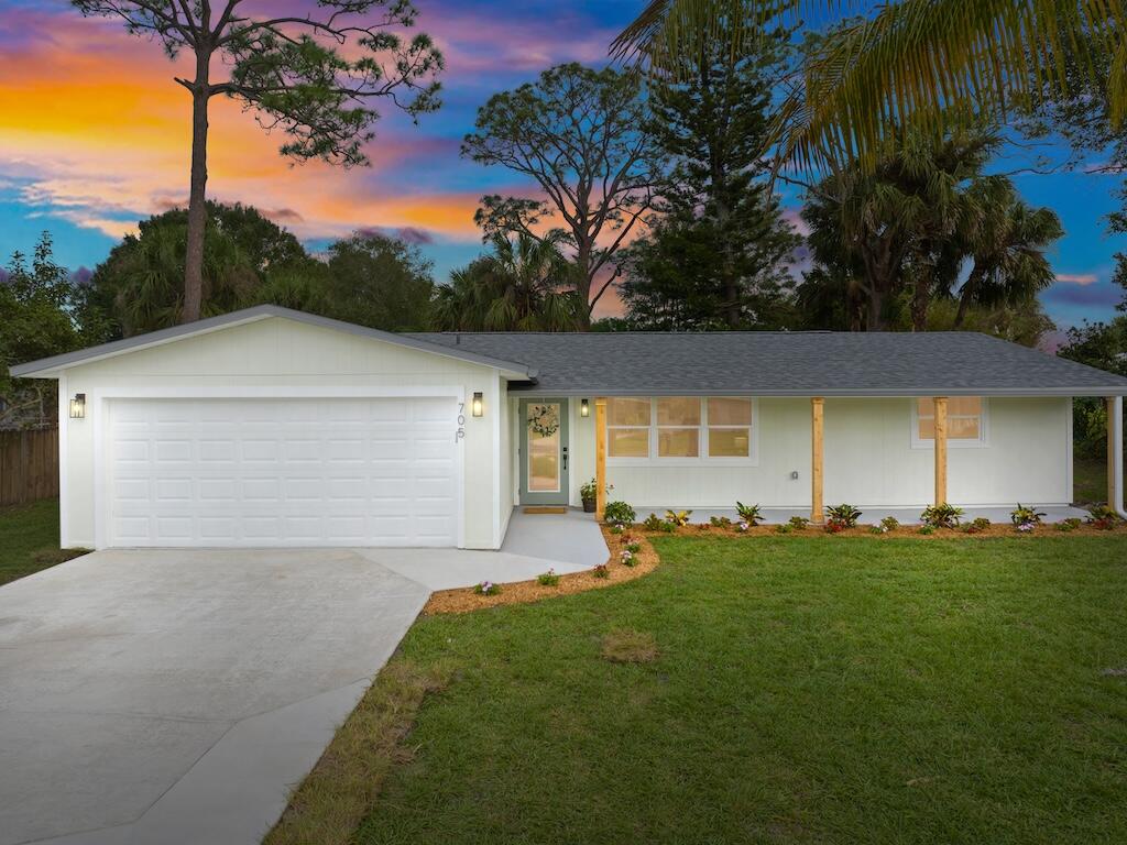 a front view of a house with a yard and trees