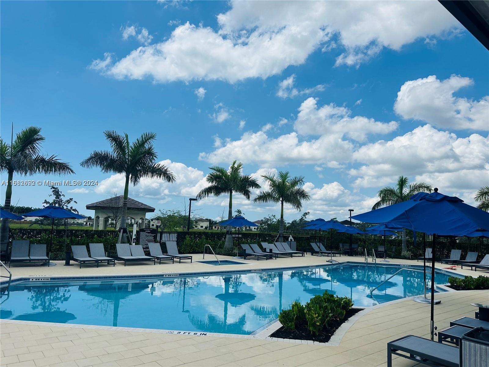 a view of a swimming pool with a table and chairs under an umbrella