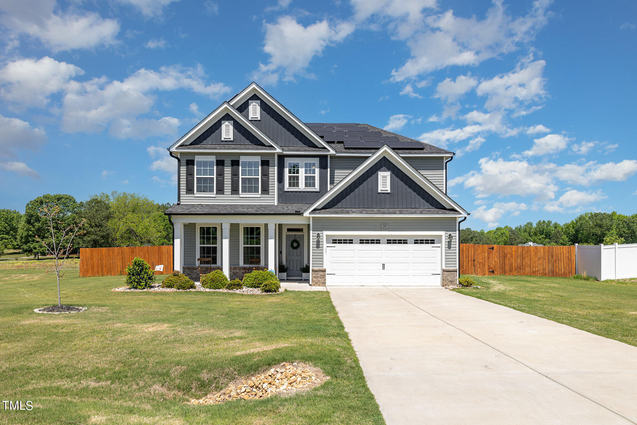 a view of a big house with a big yard and potted plants