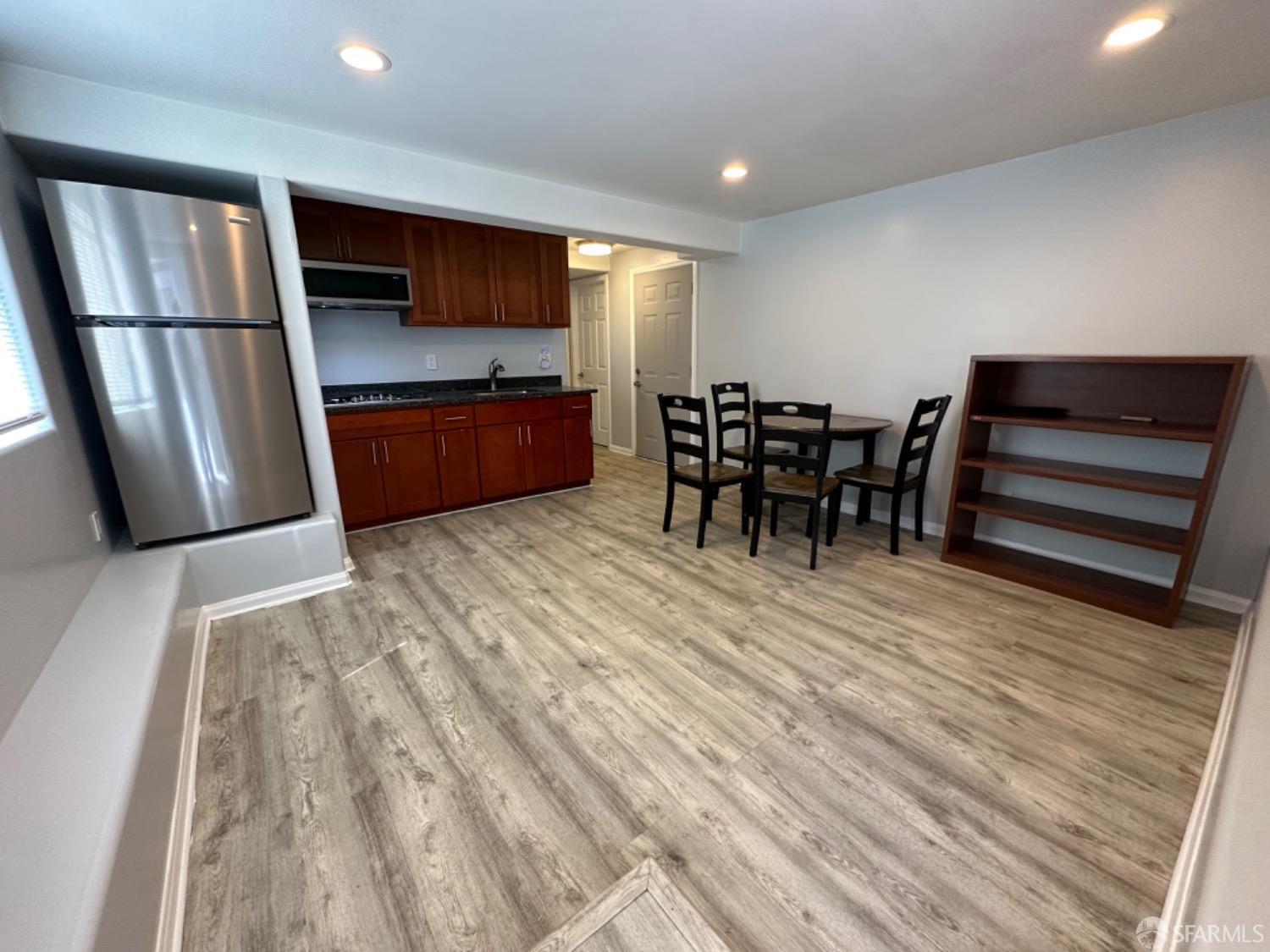a kitchen with stainless steel appliances wooden floor and chairs