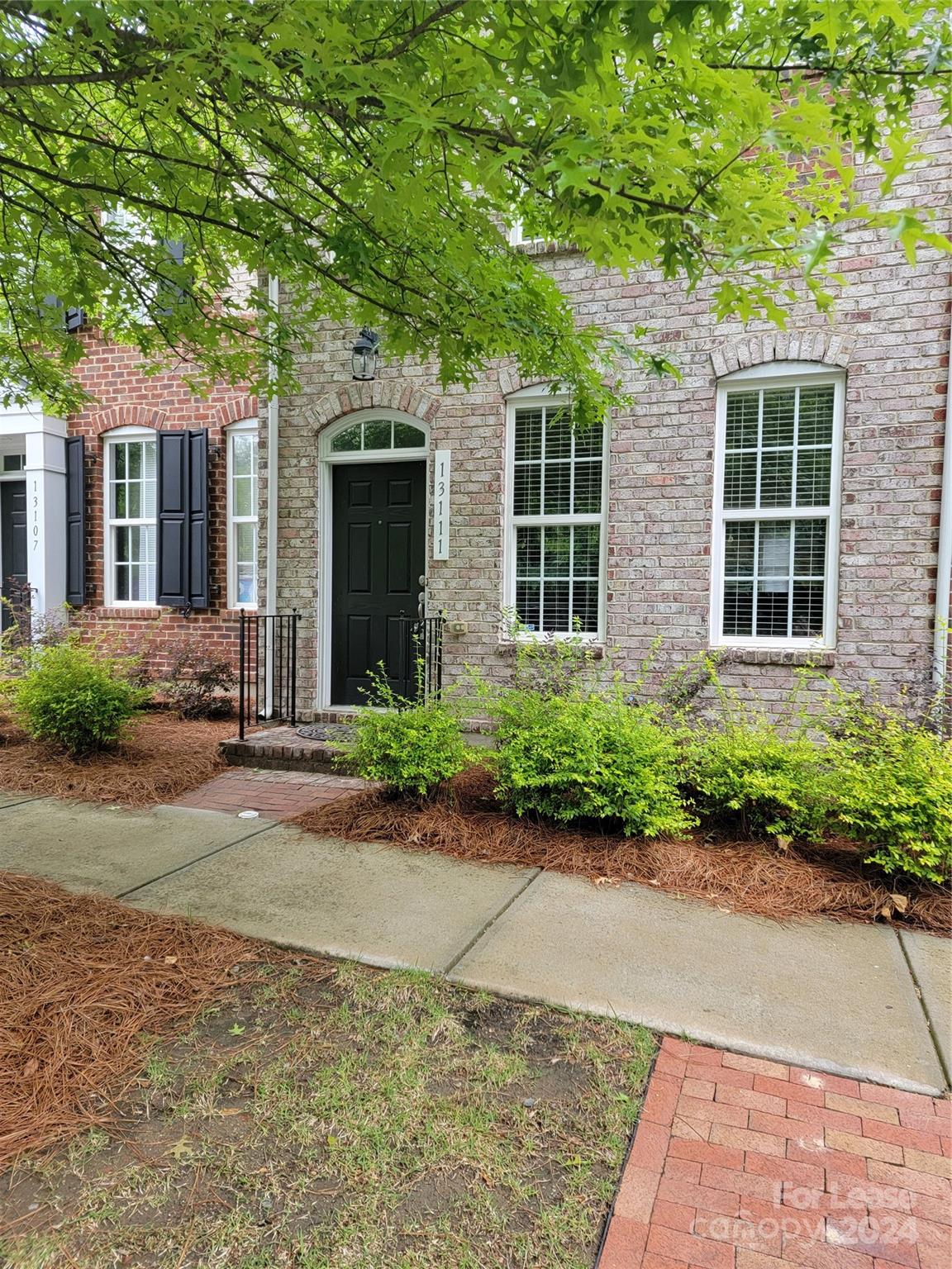 front view of a brick house with a yard