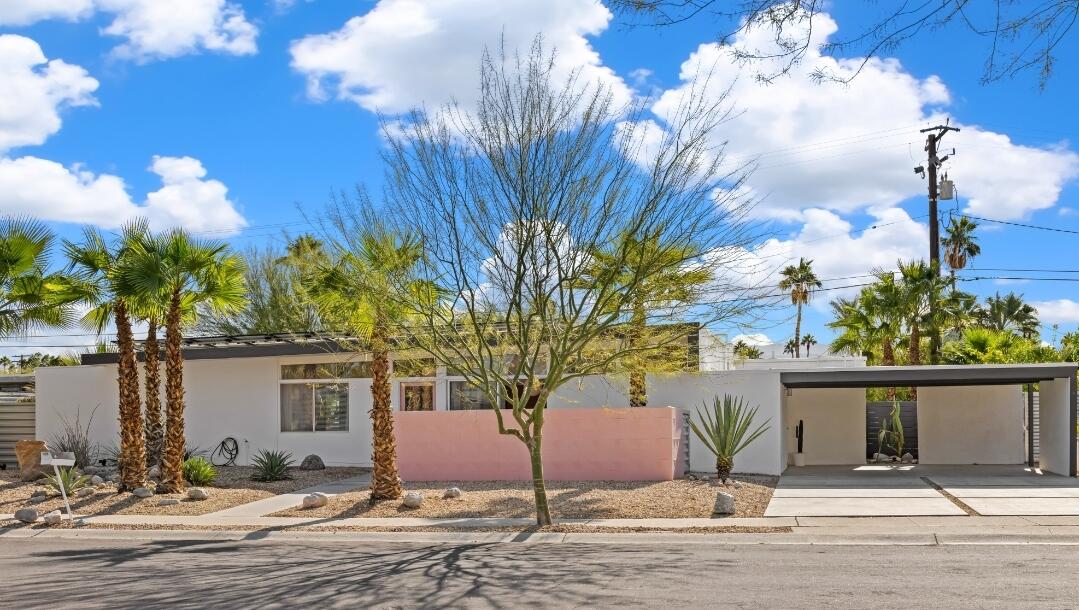 a front view of a house with a yard and tree s