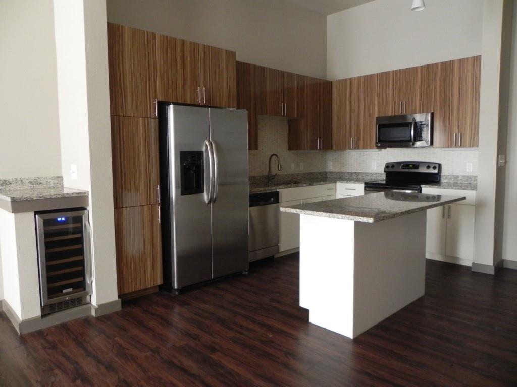 a kitchen with wooden cabinets stainless steel appliances and wooden floor