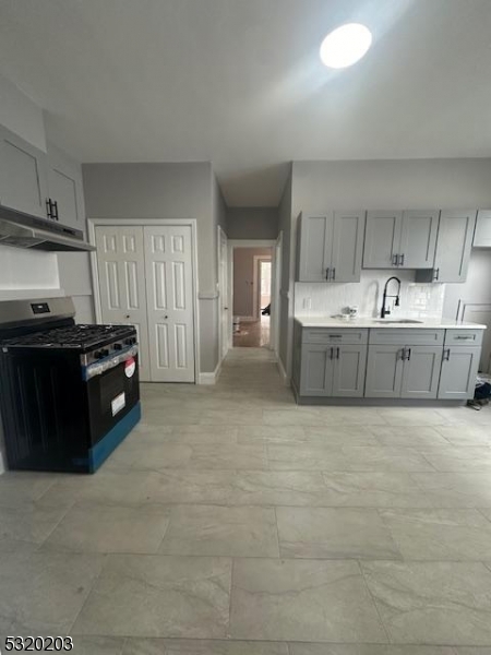 a large kitchen with stainless steel appliances granite countertop a stove and a refrigerator