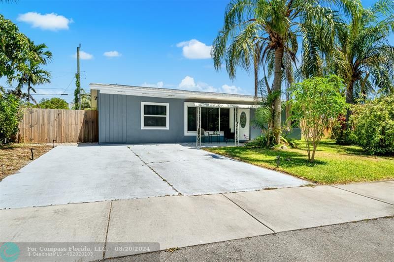 a house with a yard and palm trees