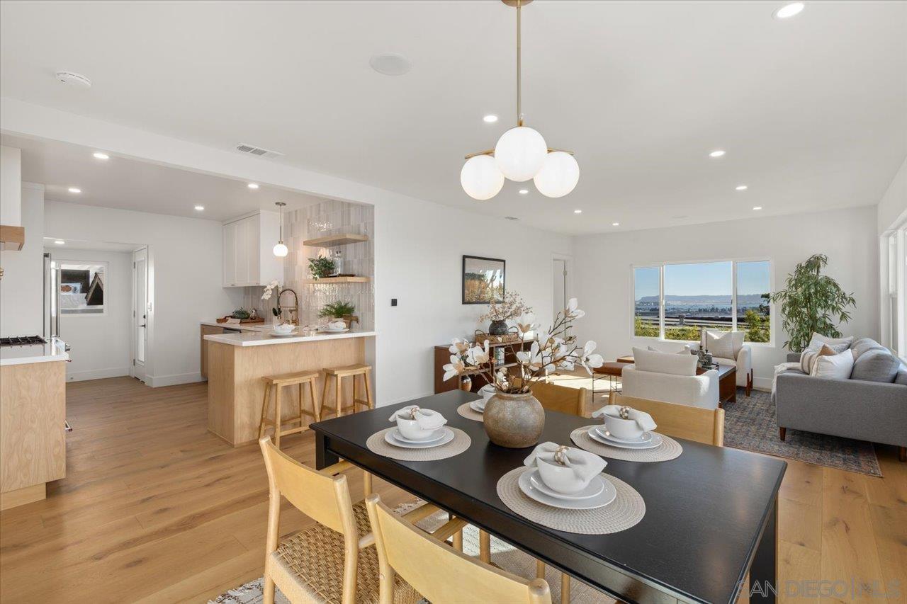 a open dining room with furniture kitchen view and a wooden floor